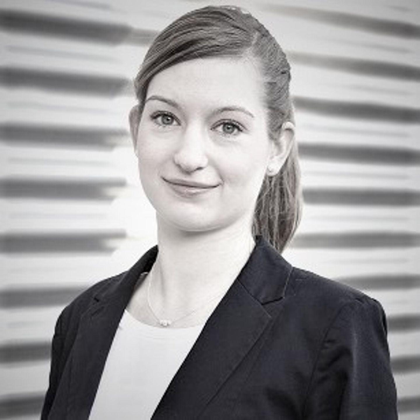 Portrait of the female expert Anja Körber, Head of Artificial Intelligence & Automation in the Otto Group, with a braid and blazer. 