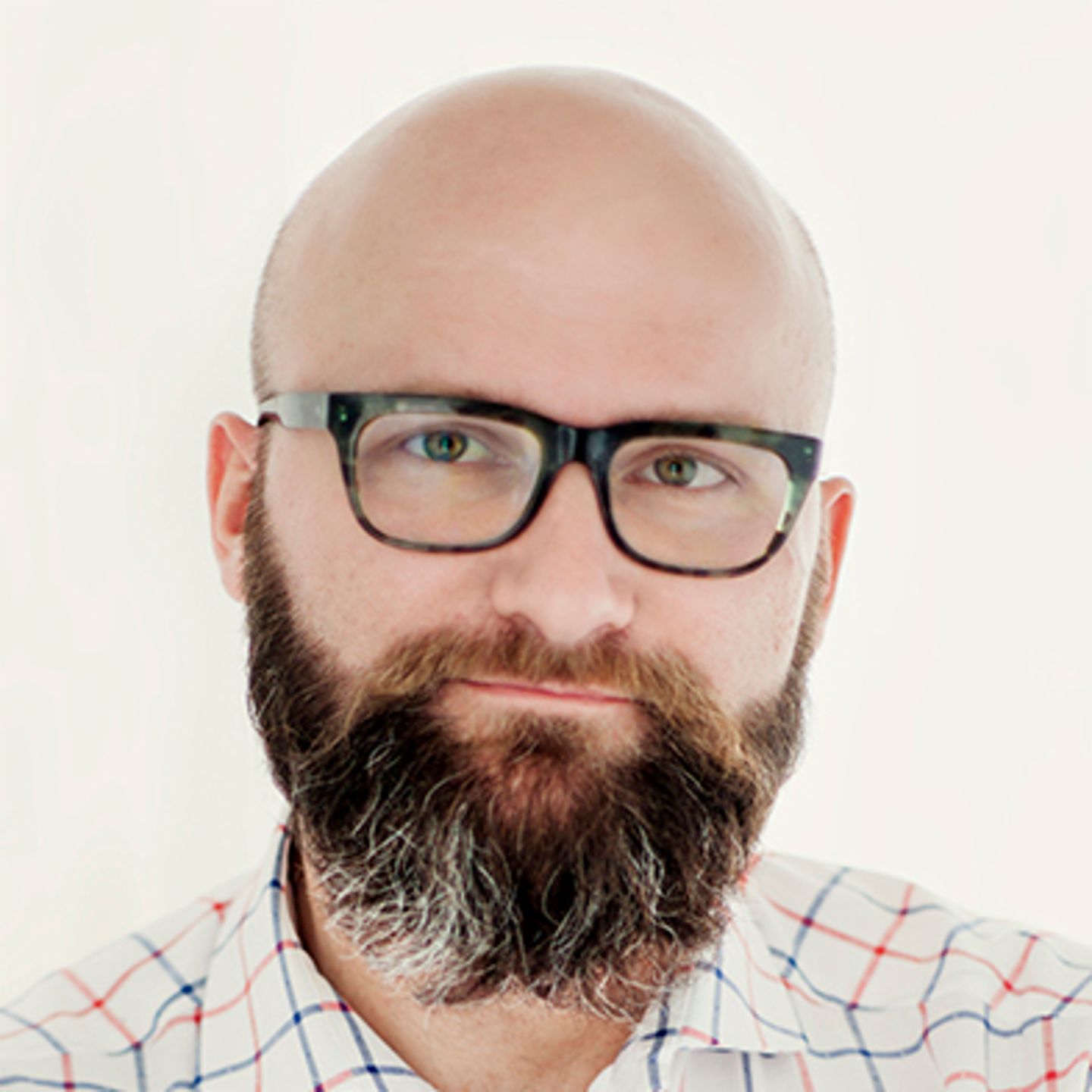 Dr. hab. Tomasz Piekot, oblečen v karirano srajco, se opira ob steno s prekrižanimi rokami.