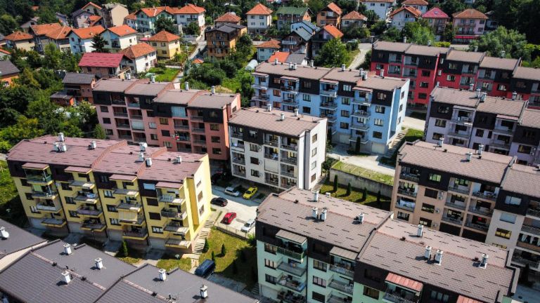 NPL, zavarovani z nepremičninami: zračni pogled na živahen stanovanjski kompleks z večbarvnimi stanovanjskimi stavbami, obdanimi z zelenimi površinami v Bosni in Hercegovini