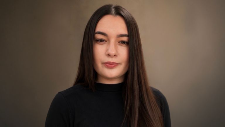 Daniela Moaca, Senior Manager IT pri EOS Romania, portretna fotografija v temnem puloverju z zavihanim ovratnikom.