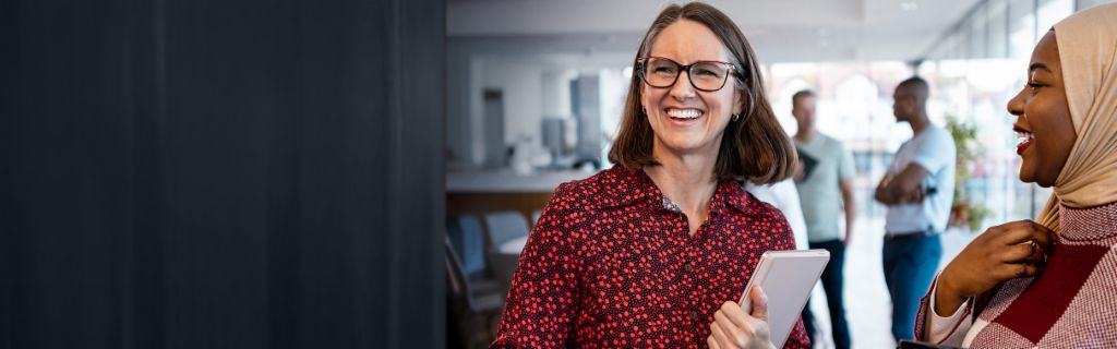 Two happy women having a casual office chat