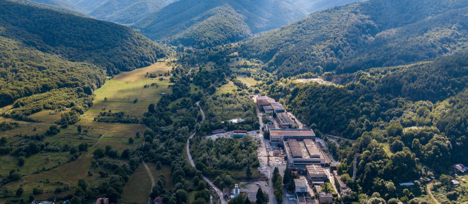 Receivables management: The image shows an aerial view of the marble factory in Berkovitsa, surrounded by many trees in a valley. Due to EOS's commitment, the traditional company was preserved.