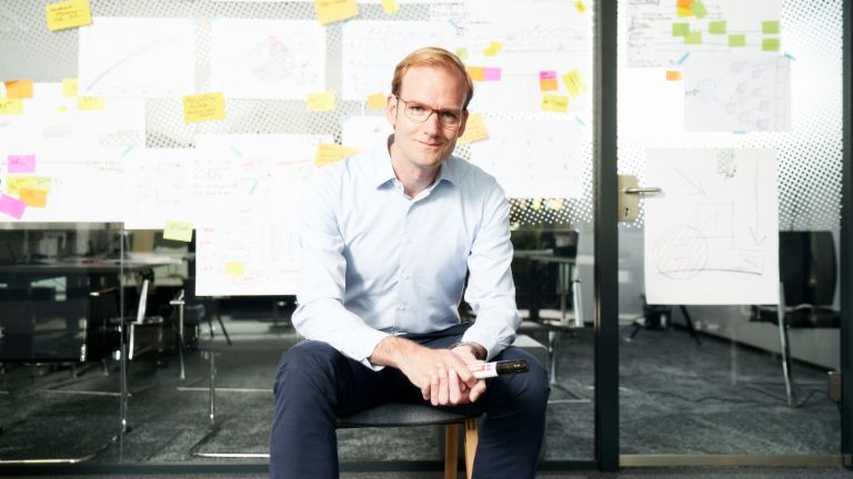 Receivables purchasing: Matthias Schmidt, Head of Operational Debt Purchase at EOS Group, sits in front of a wall covered in post-its and other notes.